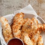 Tender, savory Coconut Chicken strips are easy and delicious! You can bake them or fry them. You choose! Great step by step instructions on www.Embellishmints.com