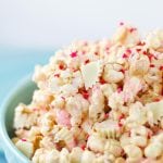 This White Chocolate Peanut Butter Popcorn is a perfect Valentine's Day treat! A blend of white chocolate, peanut butter, peanuts, and Reese's White Chocolate Peanut Butter Cups! Find the recipes on www.Embellishmints.com