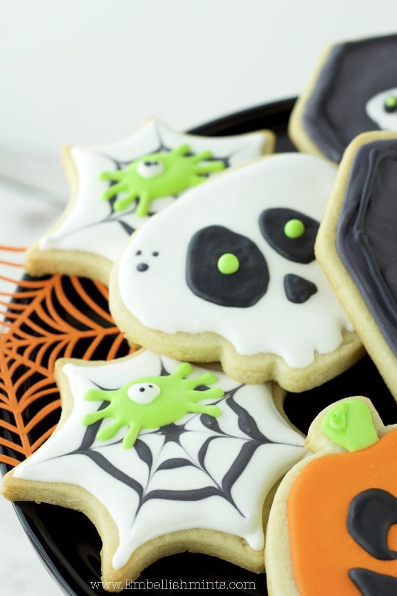 Watch how I made these super fun Halloween Spiderweb Cookies using Royal Icing. Get inspired for Halloween with these Spiderweb Cookies. www.Embellishmints.com